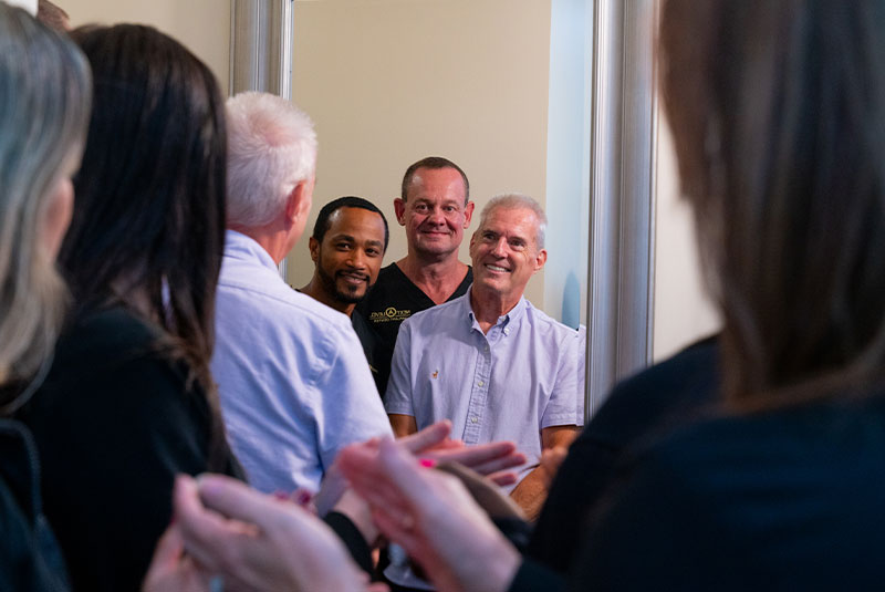Dr. Stevenson Dr. Wiltz. with patient and team smiling in mirror